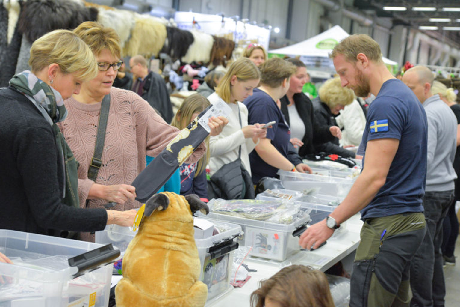A group of people checking out the products in a booth at the trade exhibition.