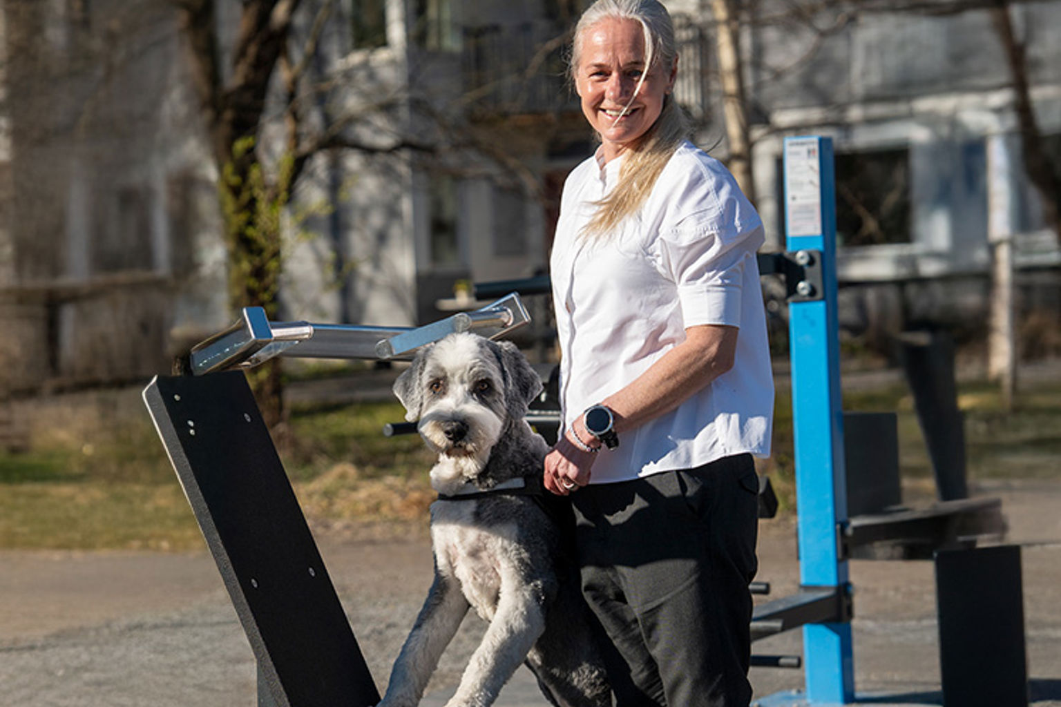 Svenska Kennelklubbens nya generalsekreterare Susanne Jidesten med sin bearded collie Ture, stående vid ett utomhusgym.